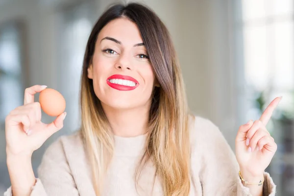 Jovem Mulher Bonita Segurando Ovo Fresco Casa Muito Feliz Apontando — Fotografia de Stock