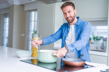 Evde makarna pişiren yakışıklı adam.