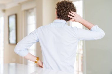 Kıvırcık saçlı genç iş adamı kafasını geriye doğru okudu ve elleri kafasında şüpheyi düşündü.