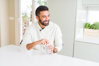 Yakışıklı adam gülümseyen bir fincan kahve içerken zevk 