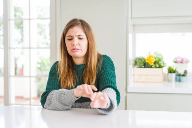 Güzel, iri yarı, sıradan çizgili bir süveter giyen, tiksindirici ve tiksindirici bir yüz ifadesi takınan genç ve güzel bir kadın. Eller havada. Can sıkıcı bir kavram..