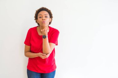 Beyaz arka plan üzerinde genç güzel afro-amerikan kadın güzel ve seksi olmak hava eliyle bir öpücük üfleme kameraya bakarak. Aşk ifadesi.