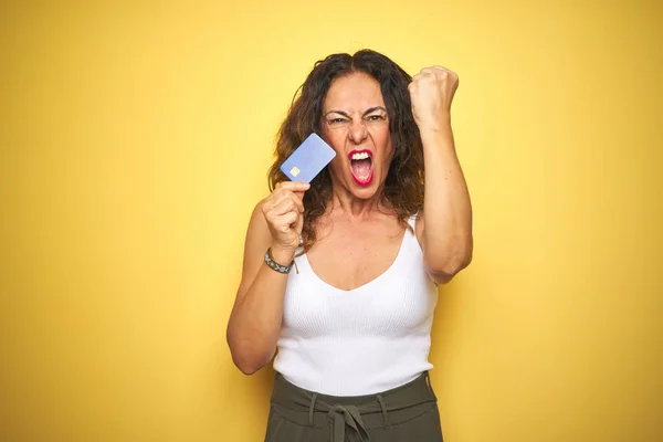 Middle Age Senior Woman Holding Credit Card Yellow Isolated Background — Stock Photo, Image