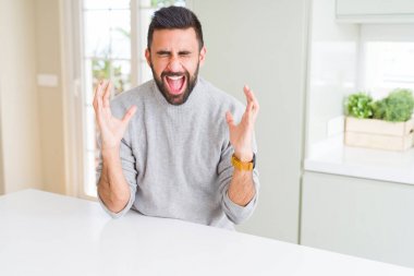 Yakışıklı İspanyol adam evde rahat kazak giyen silah kaldırdı ve kapalı gözleri heyecan çığlık ile başarı için deli ve deli kutluyor. Kazanan kavramı