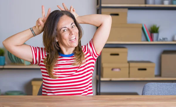 Mujer Mayor Mediana Edad Sentada Mesa Casa Posando Divertida Loca — Foto de Stock