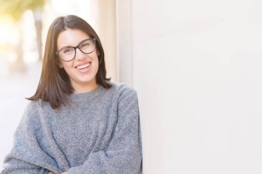Gözlüklü neşeli duvarda, kasaba, casual güzel kız eğilerek gülümseyen güzel genç kadın