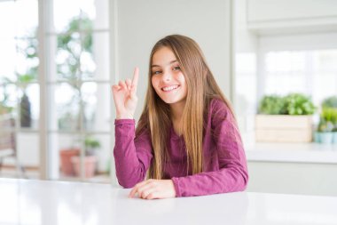 Beyaz tablo üzerinde güzel bir genç kız çocuk gösteren ve parmak numarası ile işaret kadar emin ve mutlu gülümseyen.