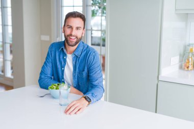 Yakışıklı adam evde yeşil bezelye yeme