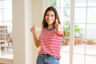 Güzel genç kadın gülümseyen heyecanlı yapıyor başparmak kadar sembolü, ok jest