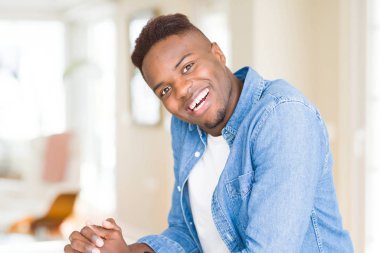 Gülümseyen yüzünde kocaman bir gülümseme ile neşeli Afrika yakışıklı genç