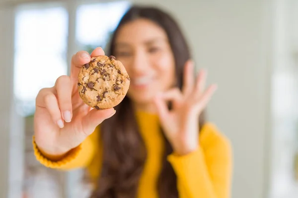 Junge Frau Isst Schokoladenkekse Hause Tut Zeichen Mit Den Fingern — Stockfoto