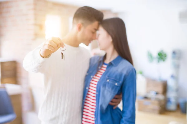 Young asian couple holding keys of new house, smiling happy and excited moving to a new apartment