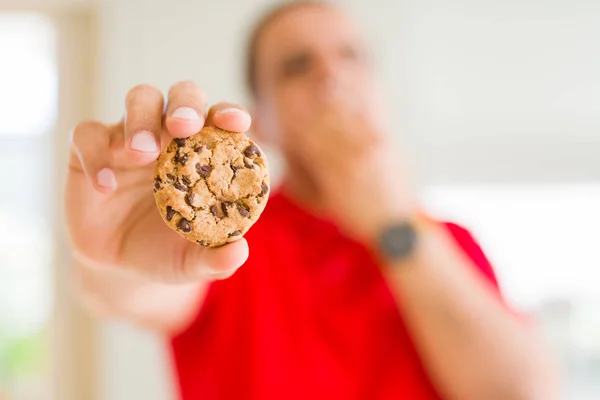 Mann Mittleren Alters Der Hause Schokoladenkekse Isst Bedeckt Mund Mit — Stockfoto