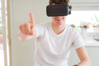 Genç adam eğleniyor evde sanal gerçeklik gözlüklü