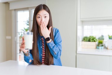 Güzel Asya kadın süt taze bir bardak içme el ile hata için utanç, korku ifade, sessizlik, gizli kavramı korkmuş ile şok ağzı kapağı