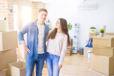 Güzel genç çift aşık ve yeni bir ev için mutlu gülümseyen yeni bir eve hareketli tahta tutarak sarılmak