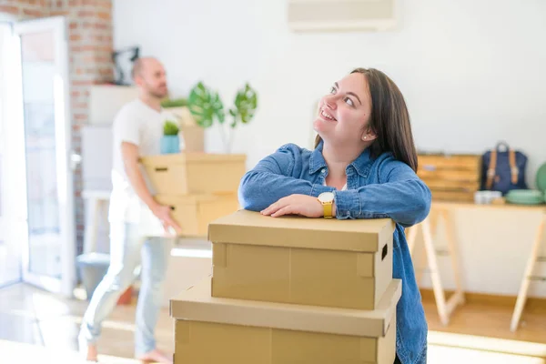 Young couple moving to new apartment, beautiful woman leaning on boxes
