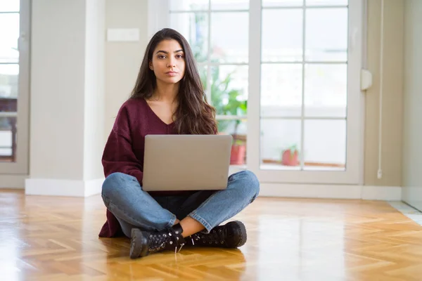 Mujer Joven Usando Computadora Portátil Sentada Suelo Con Expresión Seria —  Fotos de Stock