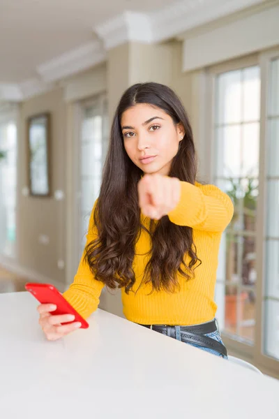 Młoda Kobieta Pomocą Czerwonego Smartfona Wysyłając Wiadomość Wskazująca Palcem Aparatu — Zdjęcie stockowe