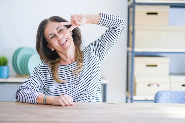 Mulher Idosa Meia Idade Sentada Mesa Casa Fazendo Símbolo Paz — Fotografia de Stock