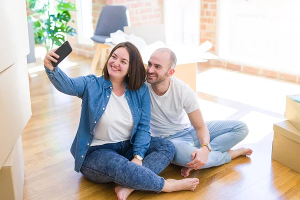 Νεαρό ζευγάρι λήψη φωτογραφίας φωτογραφία χρησιμοποιώντας το smartphone στο νέο σπίτι — Φωτογραφία Αρχείου