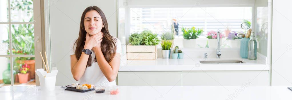 Wide angle picture of beautiful young woman eating asian sushi from delivery shouting and suffocate because painful strangle. Health problem. Asphyxiate and suicide concept.