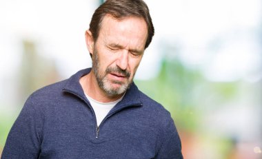 Orta yaş yakışıklı adam çünkü mide üzerinde el ile kazak giyen hazımsızlık, ağrılı hastalık hasta hissediyor. Ağrısı kavramı.