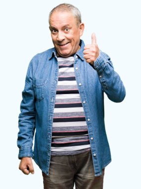 Hareketi el ile mutlu yaşasın yapıyor kot ceket giymiş yakışıklı komuta sizde. Kameraya bakarak başarı gösteren ile ifade onaylama.