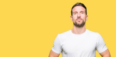 Yakışıklı adamın Casual beyaz t-shirt eller birlikte giydiğini ve parmakları rahat ve neşeli gülümseyen geçti. Başarı ve iyimser