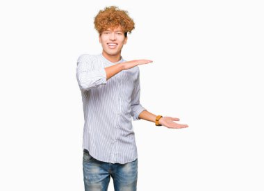 Genç yakışıklı iş adam ile afro saç giyen zarif gömlek el ile gösteren büyük ve büyük boyut işareti, ölçmek sembolü. Kameraya bakarak gülümsüyor. Ölçme konsepti.