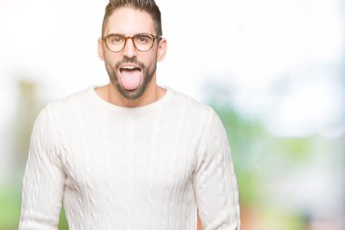 Genç yakışıklı adam gözlük dilini izole arka plan üzerinde mutlu komik ifade ile dışarı. Duygu kavramı.