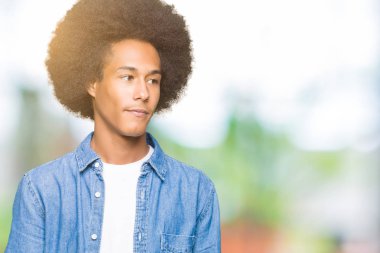 Afrikalı-Amerikalı genç afro saçlı uzak tarafına yüzünde, doğal ifade gülümseme ile arıyorum. Kendine güvenen gülüyor.