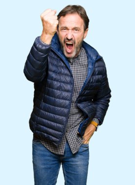 Orta yaş yakışıklı adam kışlık ceket kızgın ve deli yetiştirmek yumruk sinirli ve öfkeli öfke ile bağırarak giyiyor. Öfke ve agresif kavram.