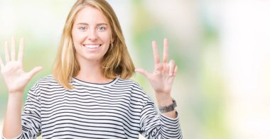 Güzel genç kadın giyiyor çizgili süveter gösterilen ve parmakları ile işaret izole arka plan üzerinde kendinden emin ve mutlu gülümseyerek süre sekiz numara.