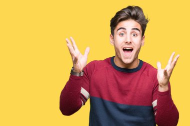 Yakışıklı delikanlı deli kutluyor ve silah ile başarı için heyecanlı çığlık kaldırdı ve açık gözleri hayret izole arka plan üzerinde. Kazanan kavramı