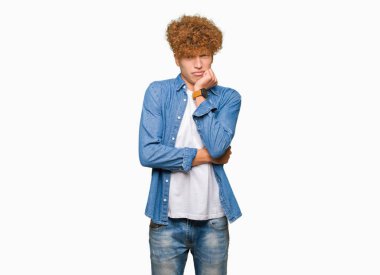 Afro saç ile genç yakışıklı adam denim ceket giymiş görünümlü vurguladı ve ağız ısırma çiviler eller ile gergin. Anksiyete sorunu.