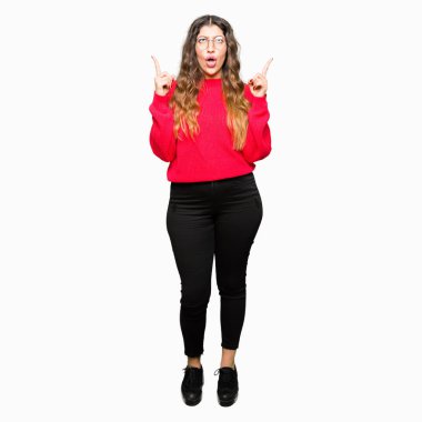 Kırmızı gözlük takan genç güzel kadın hayrete ve yukarıya bakıyor ve parmakları ile işaret ve silah kaldırdı şaşırttı.