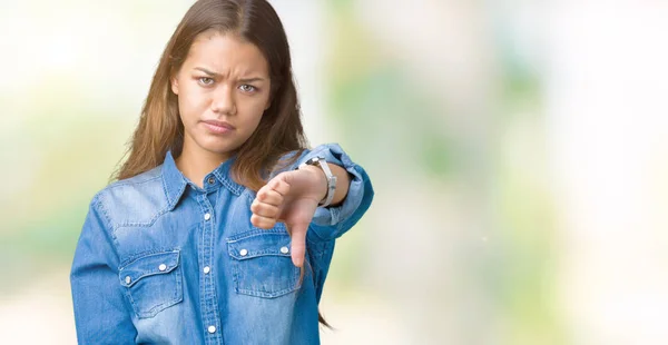 年轻美丽的黑发女人穿着蓝色粗斜纹棉布衬衫在孤立的背景看起来不开心和愤怒显示拒绝和负面的大拇指向下的姿态 错误的表达 — 图库照片