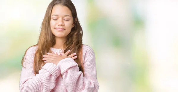 年轻美丽的黑发女人穿着粉红色的冬季毛衣在孤立的背景微笑着双手在胸前闭着眼睛 并在脸上感激的姿态 健康理念 — 图库照片