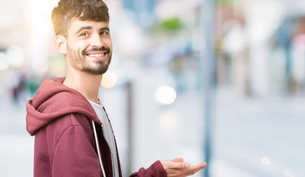 Jonge Knappe Man Geïsoleerde Achtergrond Wijst Naar Kant Met Hand — Stockfoto