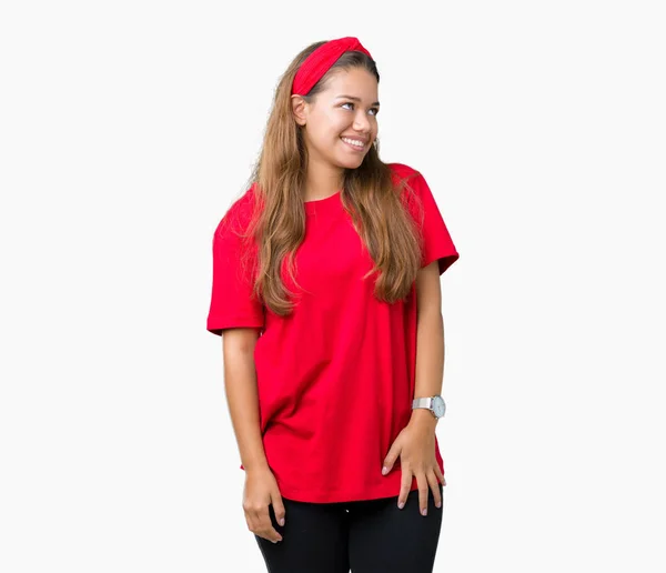 年轻美丽的黑发女人穿着红色的 T恤在孤立的背景看着一边面带微笑 自然的表情 笑自信 — 图库照片