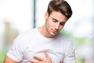 Yakışıklı delikanlı üzerinde beyaz t-shirt giyen izole mide üzerinde el ile arka plan çünkü mide bulantısı, ağrılı hastalık hasta hissediyor. Ağrısı kavramı.