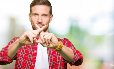 Yakışıklı adam rahat gömlek ret ifade geçiş parmakları eksi işareti yaparken giyiyor