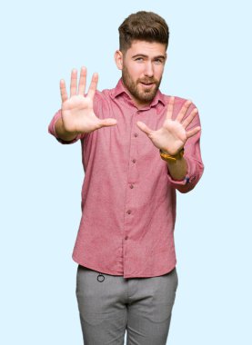 Şokta bağırarak genç yakışıklı iş casual adam korkuyor ve korku ifade dur hareketi el ile ile dehşete. Panik kavramı.