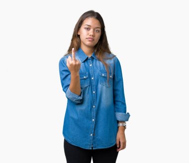 İzole arka plan gösteren orta parmak, kaba ve kaba siktir git ifade üzerinde mavi kot gömlek giyen genç güzel esmer kadın