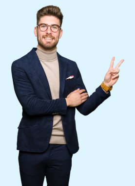 Mutlu yüz zafer işareti yaparken kameraya göz kırpıyor ile gülümseyen gözlüklü genç yakışıklı iş adamı. İki numaralı.