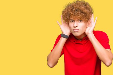 Genç yakışıklı adam ile afro saç giyen kırmızı t-shirt iki elini de kulak jestinde duymaya çalışıyorum, dedikoduyu merak ediyor. İşitme sorunu, sağır