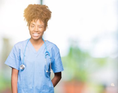 Genç Afro-Amerikan doktor kadın seksi bir ifadeyle, neşeli ve mutlu yüzünü kameraya bakarak göz kırpıyor izole arka plan.