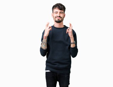 Yakışıklı delikanlı geçiş parmakları umut ve gözleri kapalı ile gülümseyen izole arka plan üzerinde. Şans ve batıl kavramı.