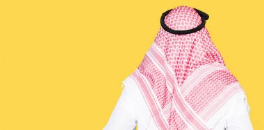Arap iş adamı uzun saçlı geriye doğru uzakta silah ile vücut üzerinde seyir ayakta geleneksel keffiyeh şal